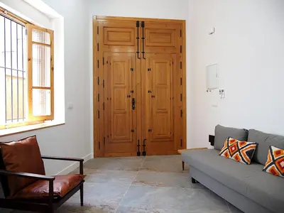 a living room with a couch and a wooden door at Apartamentos SAN JOSÉ in El Puig