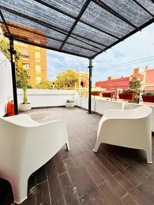 a patio with white benches on a roof at Reina loft in Valencia