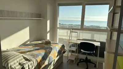 a bedroom with a bed and a desk and a window at Gran Canet, sea view 2beds in Canet de Berenguer