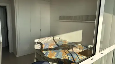 a small bed in a room with a mirror at Gran Canet, sea view 2beds in Canet de Berenguer