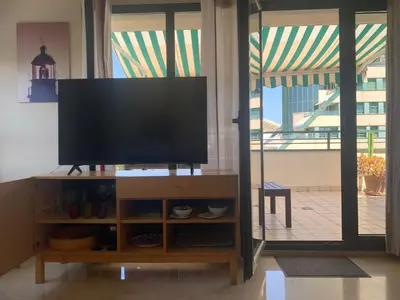 a flat screen tv sitting on top of a entertainment center at Atico Ciudad de las Ciencias Terraza y parking in Valencia