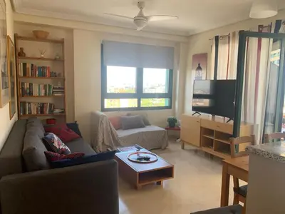 a living room with a couch and a tv at Atico Ciudad de las Ciencias Terraza y parking in Valencia