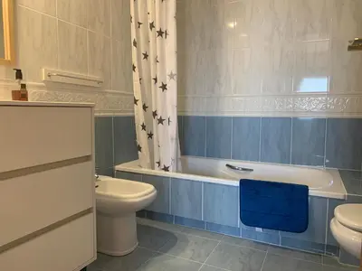 a bathroom with a toilet and a tub and a sink at Atico Ciudad de las Ciencias Terraza y parking in Valencia