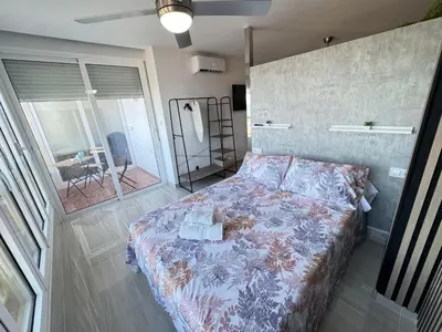 a bedroom with a bed with a floral bedspread at Suite Miramar primera línea playa in Cullera