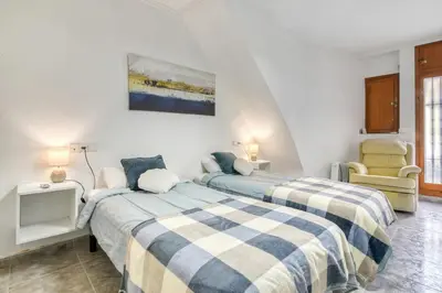 a bedroom with two beds and a chair at Casa Playa Arenas con Terraza in Valencia