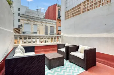 a balcony with chairs and tables on a building at Casa Playa Arenas con Terraza in Valencia