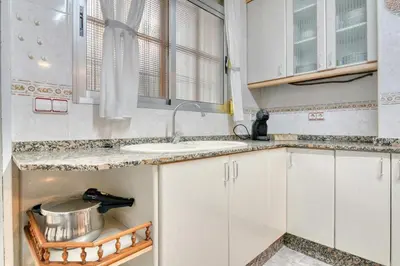 a kitchen with white cabinets and a sink at Casa Playa Arenas con Terraza in Valencia