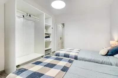 a bedroom with two beds and white walls at Casa Playa Arenas con Terraza in Valencia