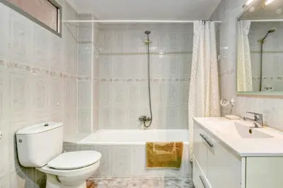 a bathroom with a toilet and a tub and a sink at Casa Playa Arenas con Terraza in Valencia