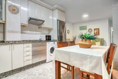 a kitchen with a table and chairs and a kitchen with a sink at Casa Playa Arenas con Terraza in Valencia