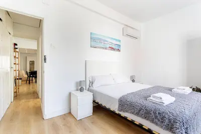 a white bedroom with a bed and a table at GuestReady - Comfort in Valencia in Valencia