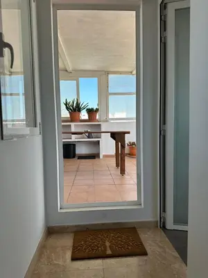 a room with a door with a view of a table at Triplex 4 Bed Penthouse Sea Views Casa Privee - Lux Four bed Two bath Terraces & Balconies in Puerto de Sagunto