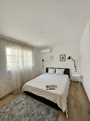a white bedroom with a bed and a lamp at Chic Escape Apartment in Godella