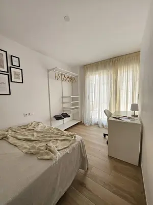 a bedroom with a bed and a desk and a window at Chic Escape Apartment in Godella