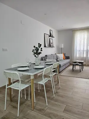 a white living room with a table and chairs at Chic Escape Apartment in Godella