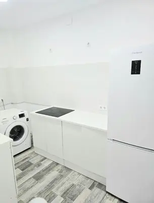 a white kitchen with a stove and a washing machine at Habitaciones La Estación in Algemesí