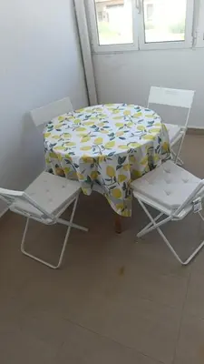 a table with two chairs and a tablecloth with flowers at First Floor Casa Privee - Two bed Beach Terrace & Balconies in Puerto de Sagunto