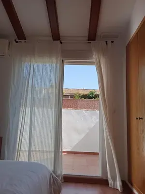 a bedroom with a bed and a large window at Valencia Casa Rosa in Sedaví