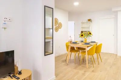 a dining room with a table and yellow chairs at VL - Casa Girasol in Valencia