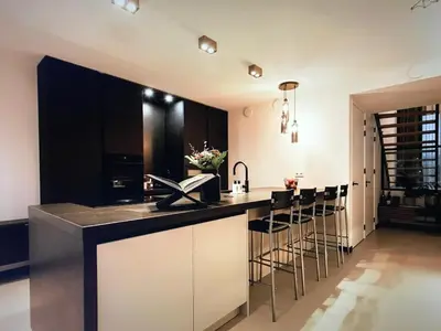 a kitchen with black and white cabinets and bar stools at Costa de Valencia Comfort in Torrent