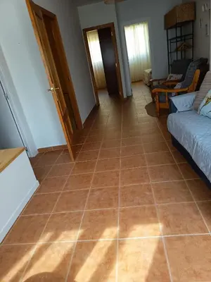 a living room with a tiled floor and a couch at La Senia in Moncófar