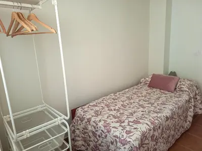 a bedroom with a bed and a clothes rack at La Senia in Moncófar