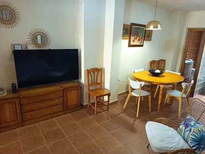 a living room with a television and a table with chairs at La Senia in Moncófar