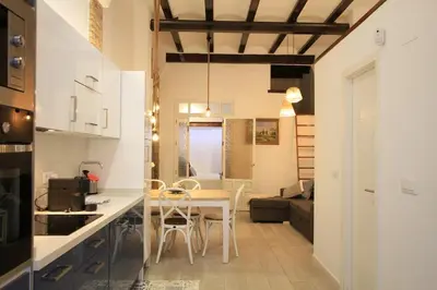 a kitchen and living room with a table and chairs at Modernist house in Cabanyal in Valencia