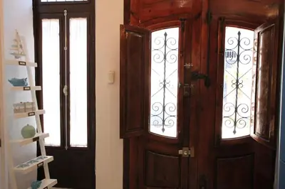 a wooden door and two windows in a room at Modernist house in Cabanyal in Valencia