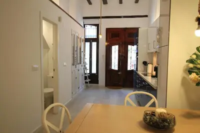 a kitchen and dining room with a wooden table and chairs at Modernist house in Cabanyal in Valencia