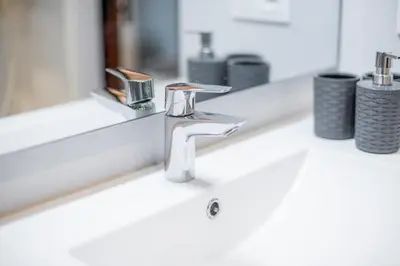 a bathroom sink with a faucet in front of a mirror at Grandma's fishermen's house in Cabanyal in Valencia
