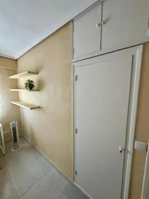 a kitchen with a wall with shelves and a door at 1st Line Beach Direct Access Private Parking in Valencia