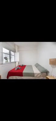 a bedroom with a bed with a red blanket and a window at Habitación luminosa en piso compartido in Valencia