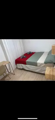 a bedroom with a bed and a chair at Habitación luminosa en piso compartido in Valencia