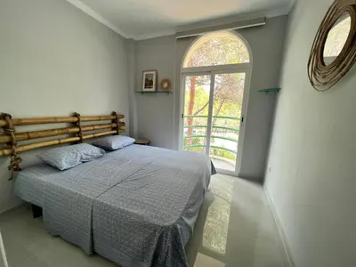 a bedroom with a bed and a large window at Luxury villa with swimming pool in the forest in Gilet