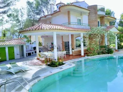 a large house with a swimming pool in front of it at Luxury villa with swimming pool in the forest in Gilet