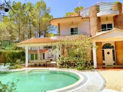 a large house with a swimming pool in front of it at Luxury villa with swimming pool in the forest in Gilet