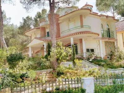 a large house with a fence in front of it at Luxury villa with swimming pool in the forest in Gilet