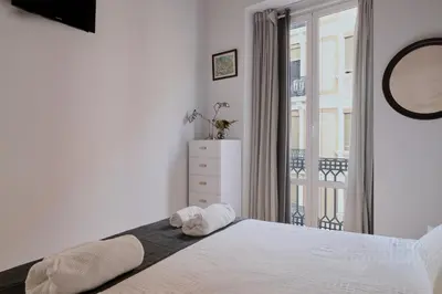 a bedroom with a white bed and a balcony at Romantic Apartment Botanico by Virkin Suites in Valencia