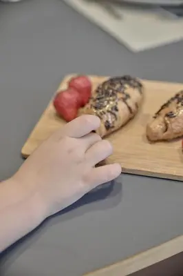 a hand is reaching for a cutting board with donuts at Romantic Apartment Botanico by Virkin Suites in Valencia