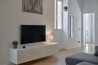 a living room with a flat screen tv on a white cabinet at Romantic Apartment Botanico by Virkin Suites in Valencia