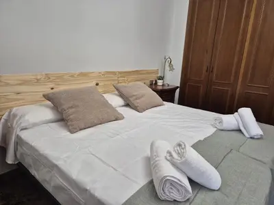 a large white bed with two pairs of towels on it at PINEDO PLAYa in Valencia
