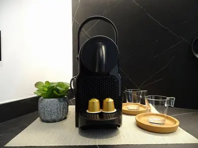 a black iron sitting on a table with two glasses at BC22 - LoftValencia in Valencia