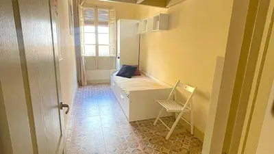 a room with a bed and a chair and a window at Apartamento Joaquín Sorolla - Patraix in Valencia