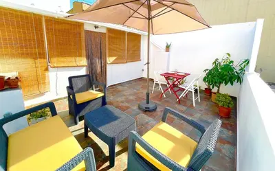 a patio with a table and chairs and an umbrella at Apartamento Joaquín Sorolla - Patraix in Valencia