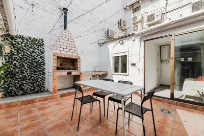 a table and chairs on a patio with a pizza oven at Hogar con encanto a 10 min del centro de Valencia in Valencia