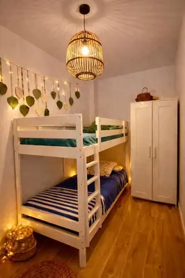a bedroom with two bunk beds and a chandelier at Maison bord de plage avec patio extérieur aménagé in Puerto de Sagunto
