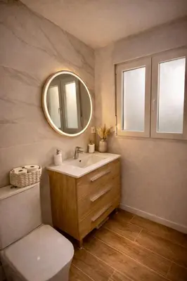 a bathroom with a sink and a mirror at Maison bord de plage avec patio extérieur aménagé in Puerto de Sagunto