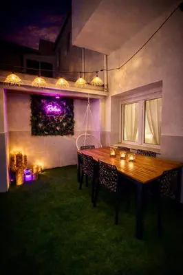 a wooden table in a yard with lights at Maison bord de plage avec patio extérieur aménagé in Puerto de Sagunto