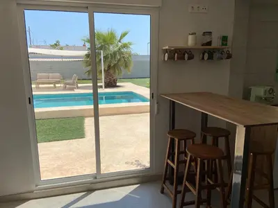 a kitchen with a sliding glass door leading to a pool at Villatella in Burriana